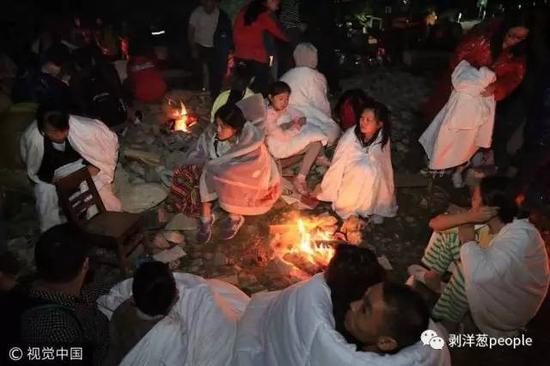 游客在路外裹着被子过夜。图片来自视觉中国