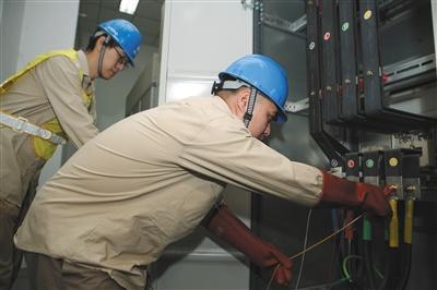  北京电科院实验室，实验人员把电能质量测试仪接入配电室控制中央空调电力输送的电箱。 