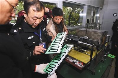 2016年12月1日,无锡,工作人员在无锡市车辆管理所为新能源车制作车牌。