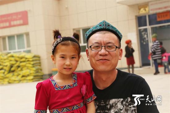 在且末县良种场义诊时,王锦辉(右)和当地的孩子合影。