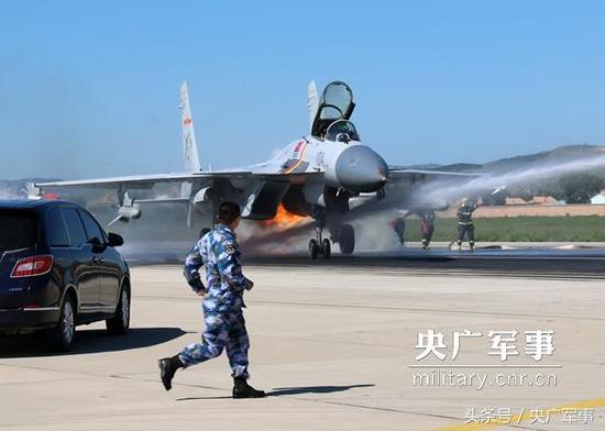 某场站官兵和机务人员第一时间围上来,扑救歼-15舰载战斗机左发动机燃起的大火。王俊柯摄