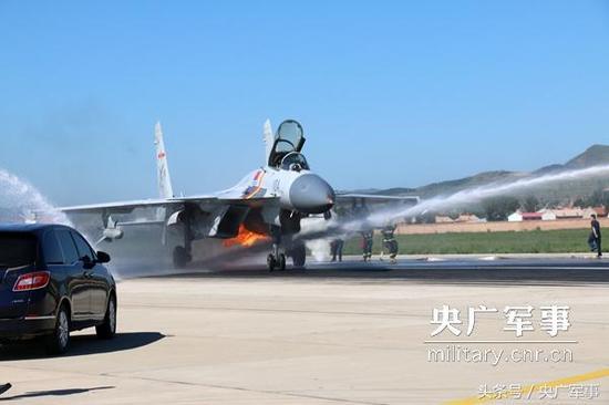 某场站官兵和机务人员第一时间围上来，扑救歼-15舰载战斗机左发动机燃起的大火。王俊柯摄