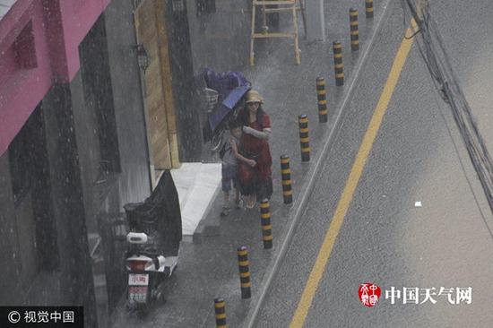 18日下午，北京遭遇强对流天气，呼家楼小学前一小街瞬间变成“小河”。（全亚军/摄 视觉中国）
