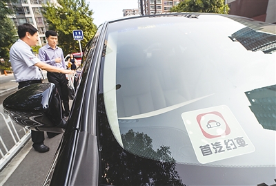 北京一家网约车公司的司机为约车的乘客打开车门。 新华社记者 罗晓光摄