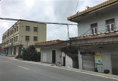 8月27日,珠海市斗门区白蕉镇新二村,中间平房为周荣家,相邻皆为楼房。