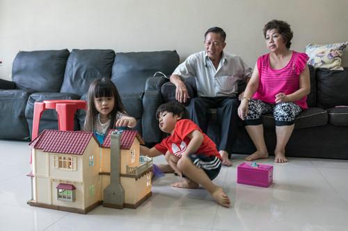 说闽南语的卓金举和他妻子刘娥娇，看着说英语的孙辈玩耍。（美国《纽约时报》网站）