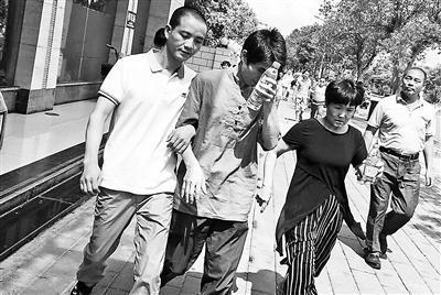 缪新华(左一)12日走出法院,重获自由 图片来源:北京青年报