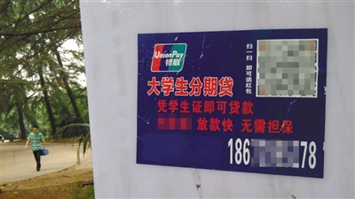 某高校校园内张贴的大学生分期贷广告,宣称“凭学生证即可贷款,放款快,无需担保。”图/视觉中国