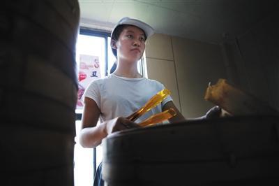 9月9日中午，南昌理工学院里的一家包子铺内，赵金凤在兼职卖包子。图片来源：新京报 