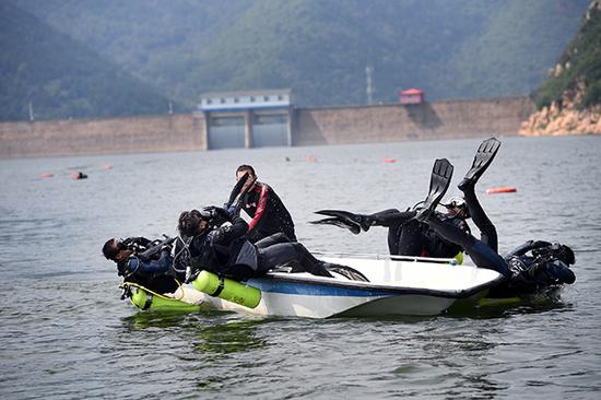 图四：2016年8月24日，特警潜水队员在小船上训练后仰式入水。