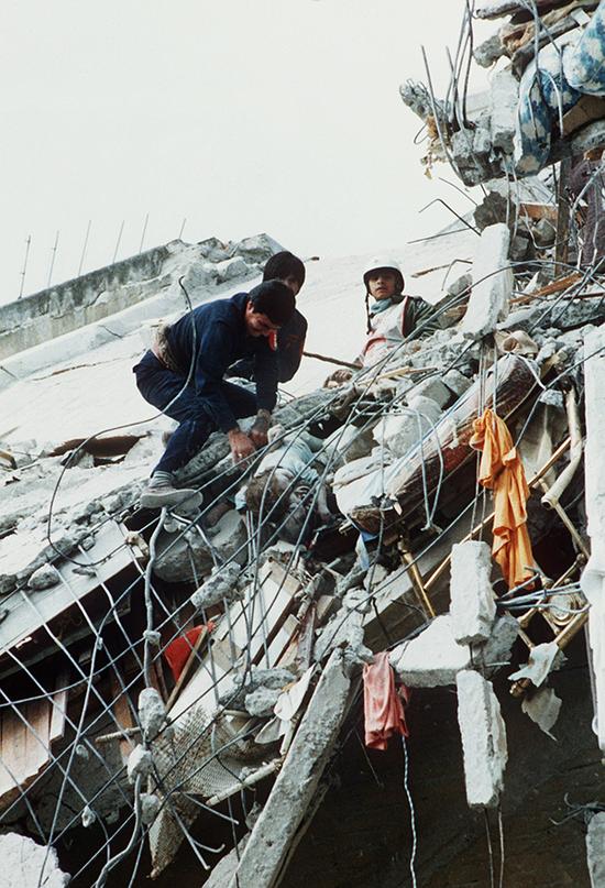 1985年9月19日，墨西哥地震后的第三天，救援人员从一妇产科病房的废墟中找到一具儿童遗体。 视觉中国 图