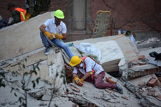 当地时间2017年9月19日，墨西哥首都墨西哥城，救援人员正在搜寻被埋的幸存者。
