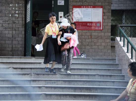 朝阳群众在帮助老人下台阶。摄/法制晚报&middot;看法新闻记者林晖