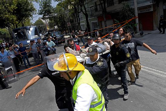 当地时间2017年9月19日，墨西哥首都墨西哥城，救援人员用担架搬运受伤民众。 视觉中国 图