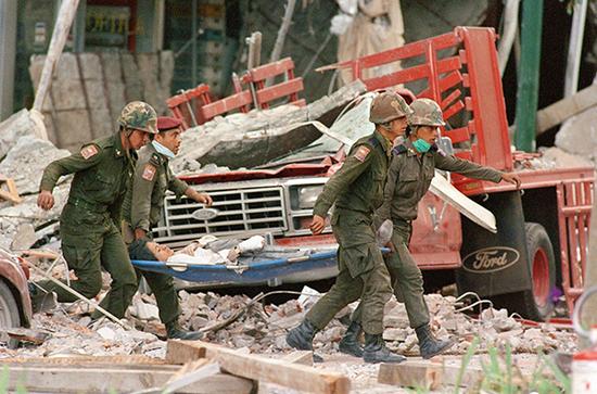 1985年9月19日地震后，士兵和志愿者正用担架搬运受伤民众。 视觉中国 资料图