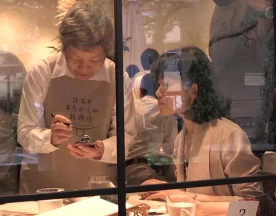 养老院的看护人员静静跟在这些服务员身后,在确认客人是否有过敏食物等时候做辅助记录。