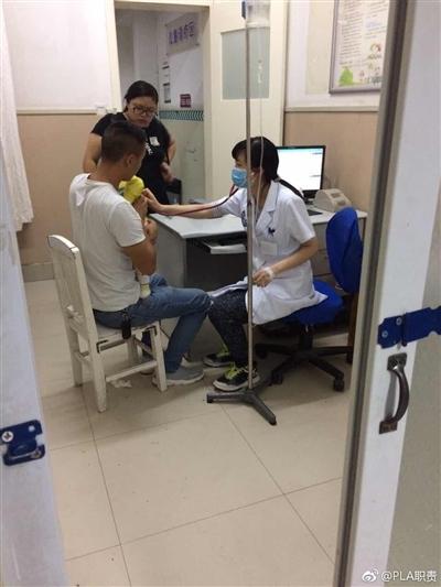 严丽娜打着吊针的同时给患者看病。