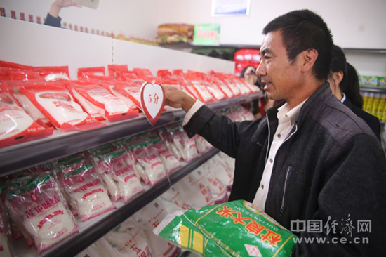 谷营镇霍寨村贫困户皇浦水在爱心超市挑选物品。（经济日报-中国经济网记者邓浩 摄）