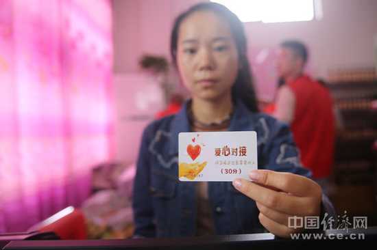 爱心超市志愿者杨楠向记者展示爱心对接卡。（经济日报-中国经济网记者邓浩 摄）