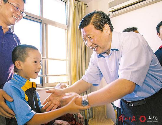 2007年10月6日，习近平来到浦东新区爱心养老公寓，与正在看望长辈的小朋友热情握手。