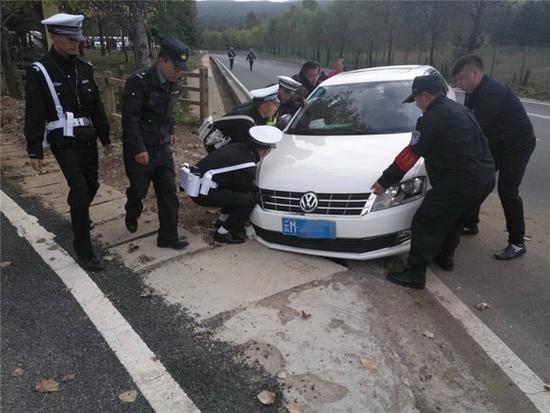 玉龙雪山景区民警正在帮抬一辆事故车