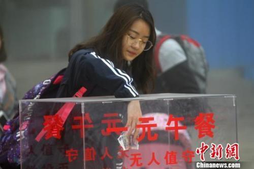 图为游客自觉投币、自助找零购买一元午餐。 王中举 摄