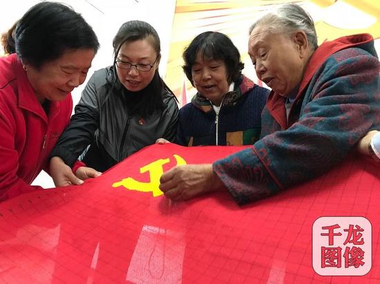 10月17日，丰台长辛店镇张家坟村党群服务站正式挂牌启动。图为几位老党员在服务站耐心地绣着一面鲜红的党旗。千龙网记者 秦胜南摄