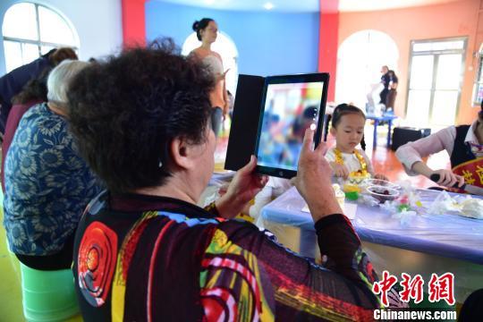 图为空巢老人用IPAD拍摄记录制作蛋糕的全过程。 王以照 摄
