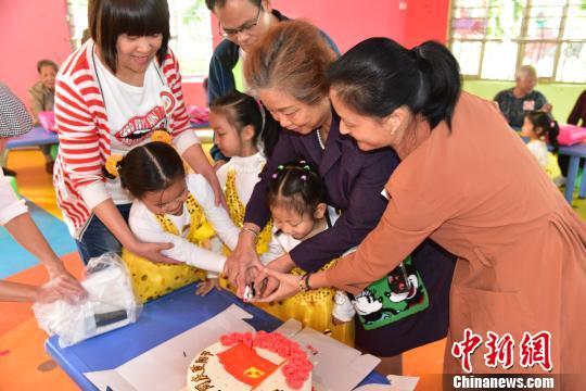 图为空巢老人与凤起新都幼儿园小朋友一起切蛋糕。 王以照 摄
