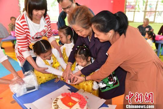 图为空巢老人与凤起新都幼儿园小朋友一起切蛋糕。　王以照 摄