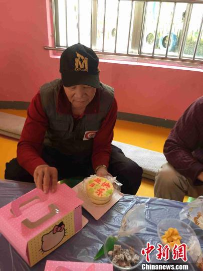 图为一名老爷爷将做好的蛋糕装进盒子。 周潇男 摄
