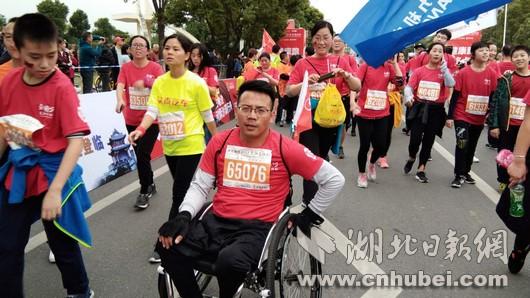 小伙坐轮椅“跑”完马拉松 每天训练10公里