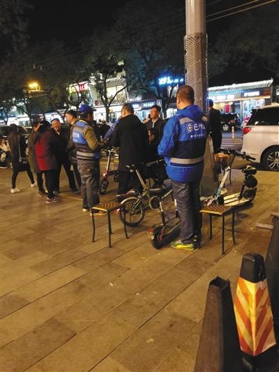11月1日晚，身着蓝色马甲、挂有工牌的e代驾人员在簋街等待客户。 罗亦丹 摄