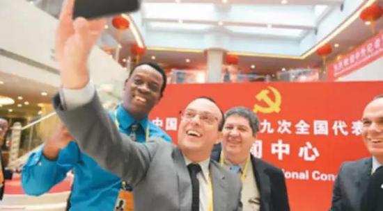 外国记者在十九大新闻中心拍照留影。胡庆明摄（人民视觉）