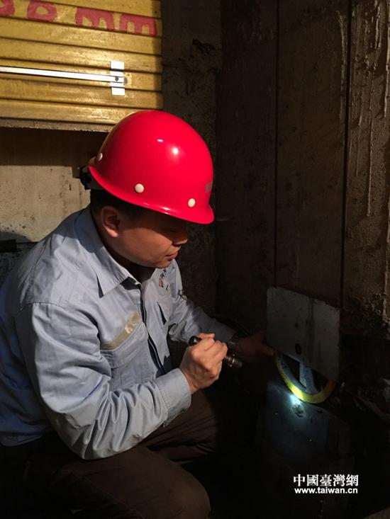 张东平在进行电梯故障检测与维修。（重庆市特种设备检测研究院供图 中国台湾网发）