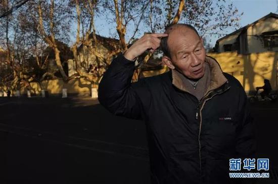 佘子清在南京西康路回忆当年被日军用枪托砸伤头部的经历（2014年12月8日摄）。　新华社记者 韩瑜庆 摄