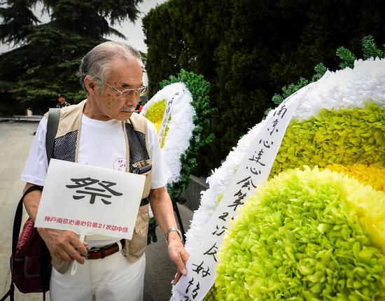  8月15日，日本“神户·南京心连心会”第21次访华团成员在整理花圈上的飘带。当日，“2017年南京国际和平集会”在侵华日军南京大屠杀遇难同胞纪念馆举行。新华社记者 季春鹏 摄