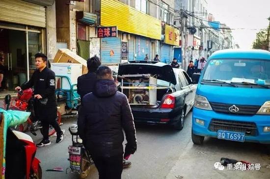 ▲11月20日，村里的主要街道被各种搬运车辆堵得水泄不通。新京报记者彭子洋摄