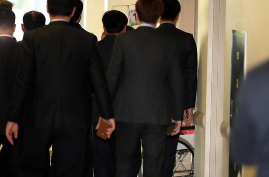  16日，朴槿惠坐轮椅住院，黑衣保安围成人墙