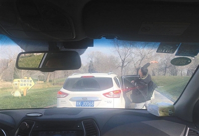 网友拍摄的图片显示，前车男子下车后朝熊区投喂食物。网友供图