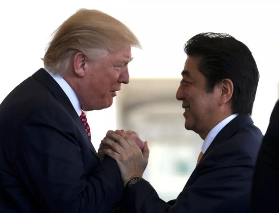 ▲资料图片：美国总统特朗普与日本首相安倍晋三寒暄。（《日本时报》）
