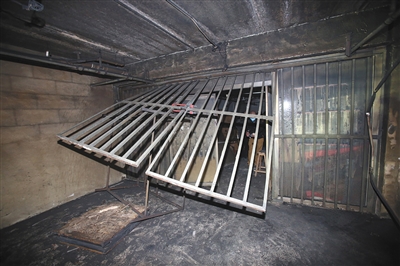 公寓一层内,一家小作坊的铁栅栏门已被救援人员撬开。