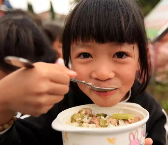 2011年11月9日，广西柳州市融安县大良镇中心小学，一名学生在吃免费午餐。（新华社记者谭凯兴 摄）