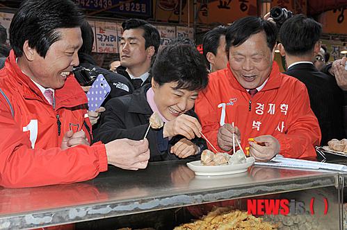 2012年3月,朴槿惠视察传统市场,品尝包子。(纽西斯通讯社)