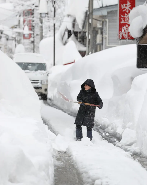 正在清理積雪的日本民眾(共同社)