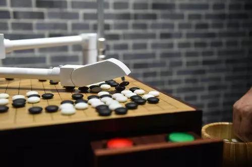 ▲资料图片:在宁波奇点机器人体验馆,展出的机器人正与一位观众现场围棋“对弈”。