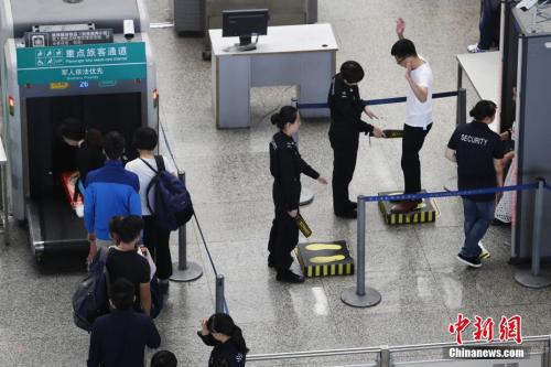 资料图:2017年10月1日,上海虹桥火车站安保人员对旅客逐一安检。张亨伟 摄