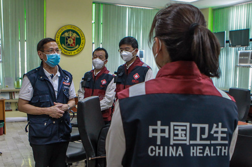 4月6日,在菲律宾首都马尼拉,中国抗疫医疗专家组成员与菲律宾卫生部长弗朗西斯科·杜凯(左)进行交流。新华社发(乌马利摄)