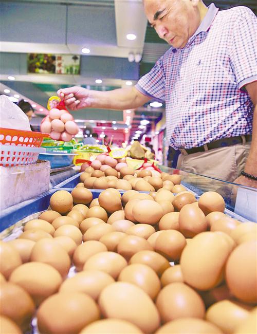 消费者在江苏南通一家菜市场选购鸡蛋。 许丛军摄（新华社发）