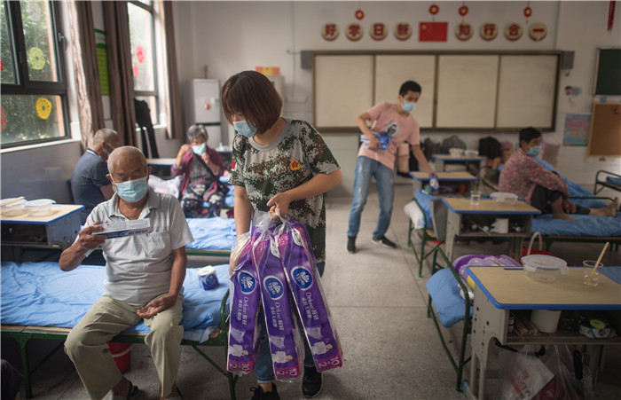 7月7日,在街道口小学东方雅园分校安置点,工作人员为武汉市洪山区天兴乡村民发放生活物资。新华社记者 肖艺九 摄
